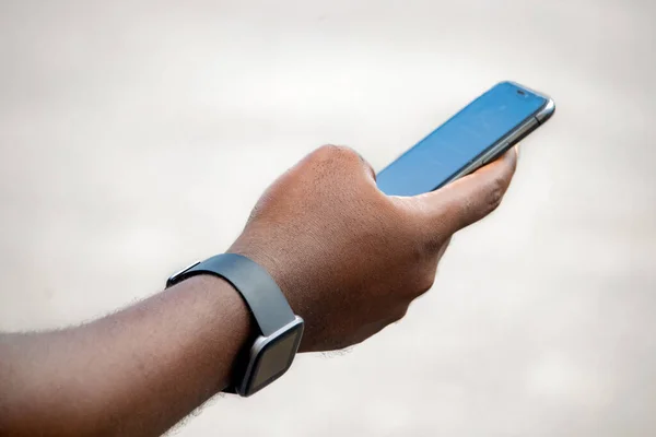 Beyaz beyaz ekran akıllı telefon tutan Afrikalı genç bir adamın eli