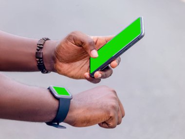 African black man pointing finger at smart phone in city , texting on mobile phone, sparkling street lifestyle, blurred background clipart