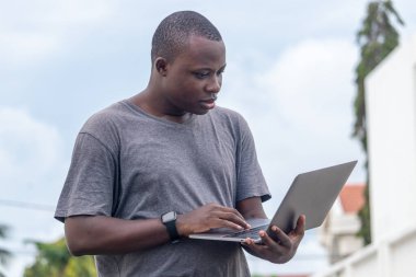 a young african man receives good news from a phone call running in a city garden clipart