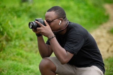 Genç bir Afrikalı eğlence için fotoğrafçılık yapıyor ve bir Afrika köyünde kendini adamış..
