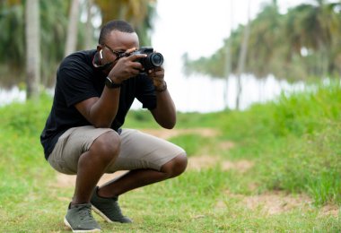 Genç bir Afrikalı eğlence için fotoğrafçılık yapıyor ve bir Afrika köyünde kendini adamış..