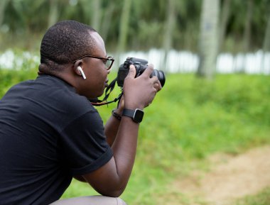 Genç bir Afrikalı eğlence için fotoğrafçılık yapıyor ve bir Afrika köyünde kendini adamış..