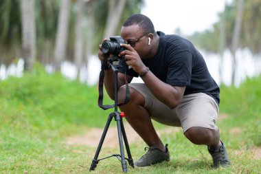 Genç bir Afrikalı eğlence için fotoğrafçılık yapıyor ve bir Afrika köyünde kendini adamış..