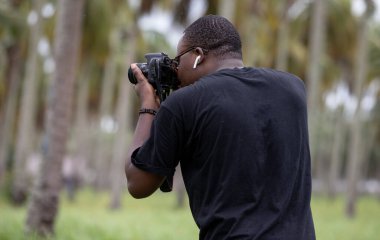 Genç bir Afrikalı eğlence için fotoğrafçılık yapıyor ve bir Afrika köyünde kendini adamış..