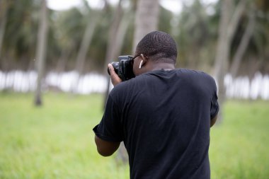 Genç bir Afrikalı eğlence için fotoğrafçılık yapıyor ve bir Afrika köyünde kendini adamış..