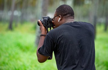 Genç bir Afrikalı eğlence için fotoğrafçılık yapıyor ve bir Afrika köyünde kendini adamış..