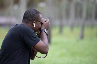 Genç bir Afrikalı eğlence için fotoğrafçılık yapıyor ve bir Afrika köyünde kendini adamış..