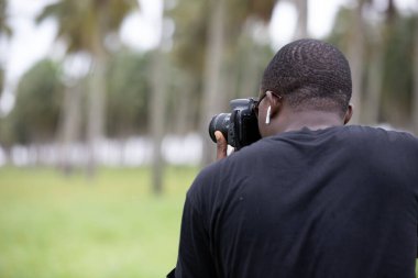 Genç bir Afrikalı eğlence için fotoğrafçılık yapıyor ve bir Afrika köyünde kendini adamış..