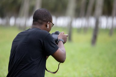Genç bir Afrikalı eğlence için fotoğrafçılık yapıyor ve bir Afrika köyünde kendini adamış..