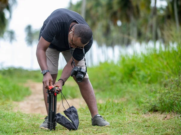 Genç bir Afrikalı eğlence için fotoğrafçılık yapıyor ve bir Afrika köyünde kendini adamış..