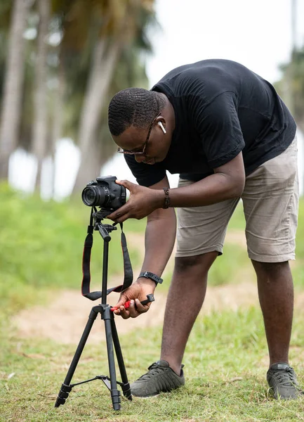 Genç bir Afrikalı eğlence için fotoğrafçılık yapıyor ve bir Afrika köyünde kendini adamış..