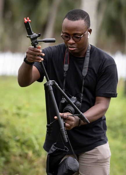 Genç bir Afrikalı eğlence için fotoğrafçılık yapıyor ve bir Afrika köyünde kendini adamış..