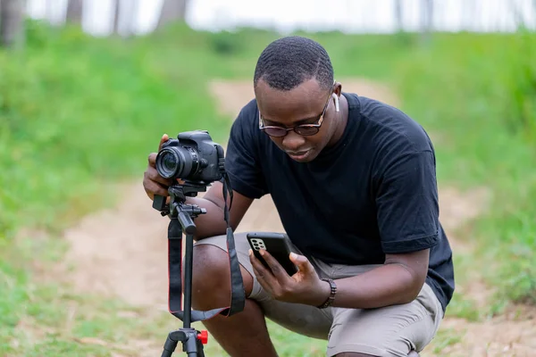Genç bir Afrikalı eğlence için fotoğrafçılık yapıyor ve bir Afrika köyünde kendini adamış..