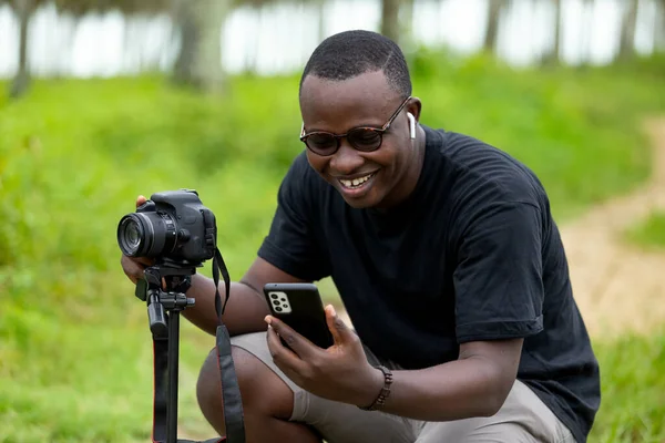 Genç bir Afrikalı eğlence için fotoğrafçılık yapıyor ve bir Afrika köyünde kendini adamış..
