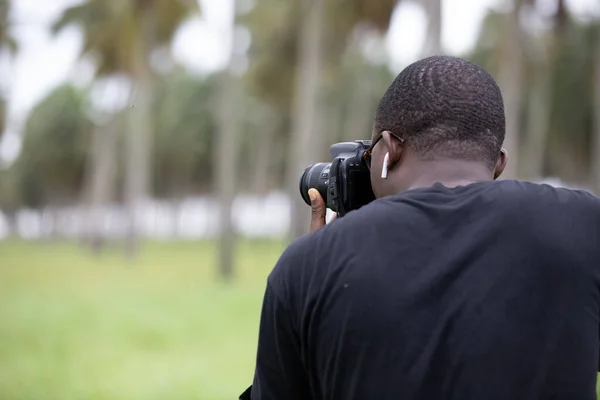 Genç bir Afrikalı eğlence için fotoğrafçılık yapıyor ve bir Afrika köyünde kendini adamış..