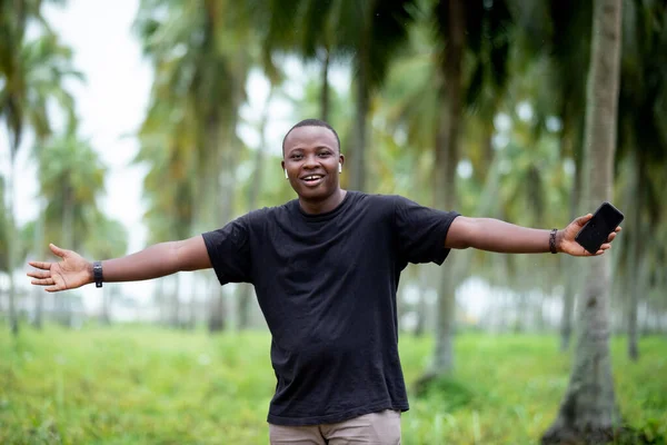 Afrika 'daki köyün neşeli, gülümseyen siyahi Afrikalı genci boş ekranı işaret ediyor..