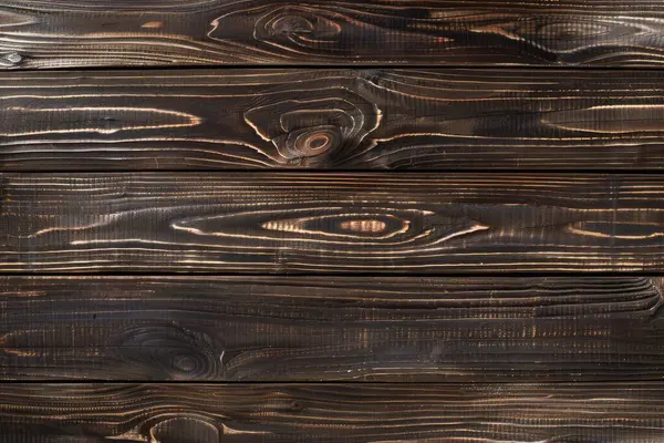 stock image This captivating image features charred wooden planks, each with its own unique grain pattern highlighted by the charring process.