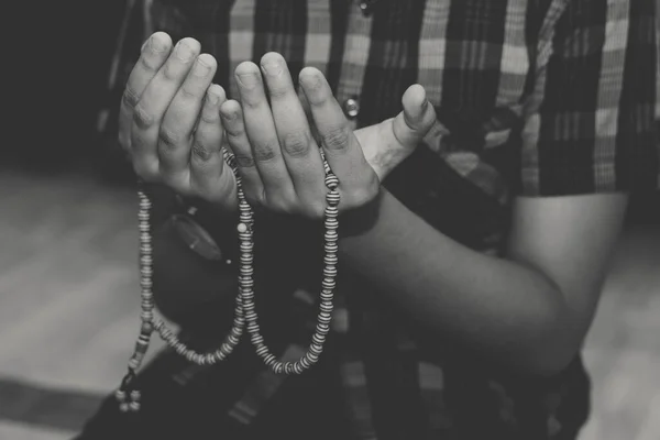 Çocuk, dua eden boncuklarla Tanrı 'ya dua ediyor. Asyalı genç, elleri açık dua ediyor..