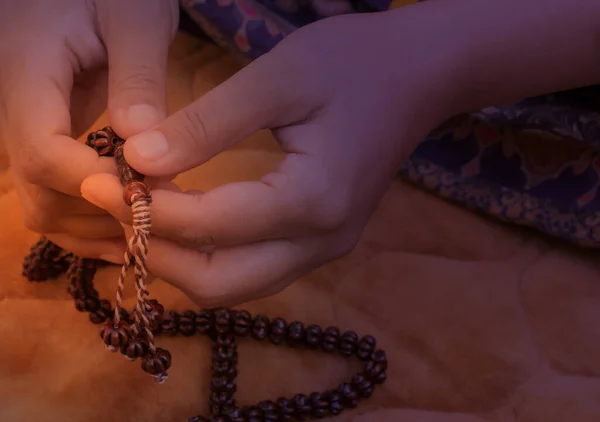 Prayer hands of a woman holding a rosary, with space for text, praying with a beat, Young Muslim girl with a rosary praying on Praying mate