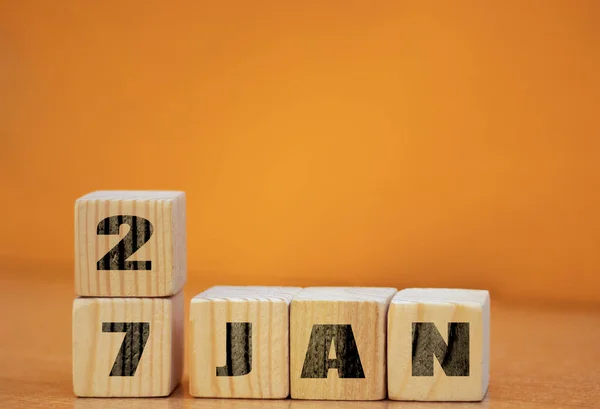 Metin için boş alanı olan tahta yüzey üzerinde 27 Ocak için küp şeklinde takvim, tarihi olan yeni yıl tahta takvimi, tahta yüzey üzerinde fotokopi alanı olan Ocak küp takvimi.