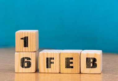 Cube shape calendar for February 16 on wooden surface with empty space for text,cube calendar for december on wood background