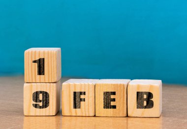 Cube shape calendar for February 19 on wooden surface with empty space for text,cube calendar for december on wood background