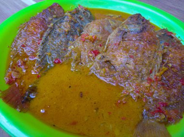 Tilapia baharatlı sosla pişirilir.