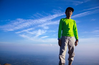 Metin mesajınız için gökyüzü arkaplanına karşı tepe üzerinde bir dağcının portresi