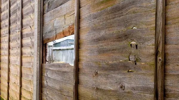 old wooden fence with a hole