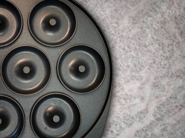 Elektrikli çörek makinesi gri mermer bir masanın üzerinde ve resim yukarıdan çekilmiş.
