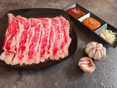 Shabu-shabu tabakları için gereken malzemeler, dilimlenmiş çiğ et ve deniz ürünlerine dayanan kaynama malzemeleridir.