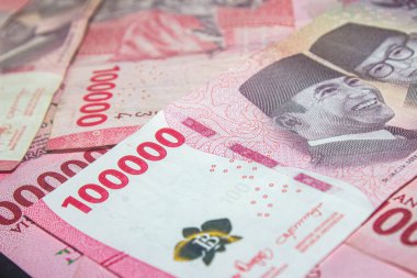 Güvenlik özellikleri ve imzaları gösteren Endonezya Rupiah banknotlarının yakın çekimi.