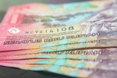 Endonezya 100,000 Rupiah 'lık yakın plan pembe tonlu banknotlar.