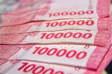 Endonezya 100,000 Rupiah 'lık yakın plan pembe tonlu banknotlar.