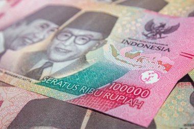 Güvenlik özellikleri ve imzaları gösteren Endonezya Rupiah banknotlarının yakın çekimi.