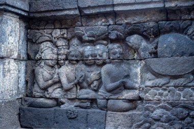 Hikaye anlatma sahnesinde oturan figürleri ve hayvanları gösteren antik taş rahatlama..