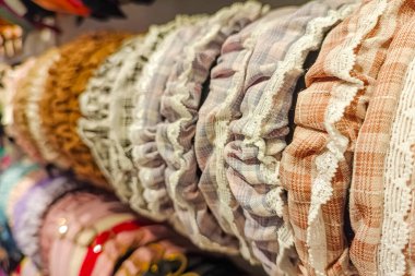 Perakende mağazasında ya da satışta satışta olan mağazada, üzerinde güzel inci detaylar bulunan dekoratif kurdele başlıkları sıralarına yakın plan seçici bir odak gösterilmektedir..