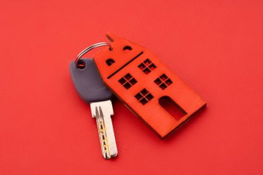Keys and house keychain. Contract agreement to buy or construction new home, insurance, registration of lease, rent apartments. House key on a house shaped keychain, moving home or renting property.