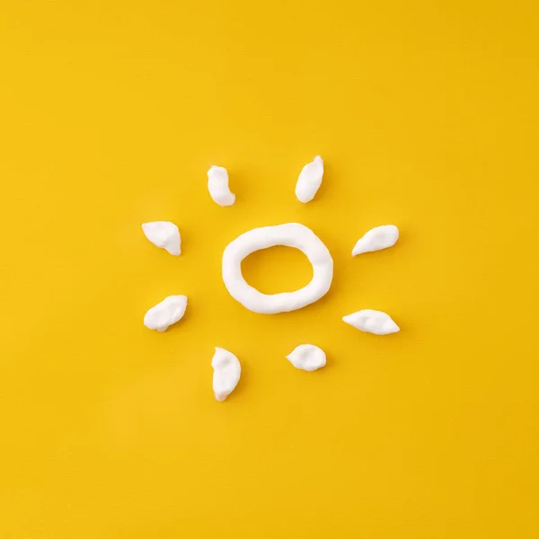 Sunscreen white sun-shaped cream. Cream in the form of sun on yellow background. Various sunscreens and sun cream on a bright yellow background. Sun protection. Ultraviolet protection. Summer.