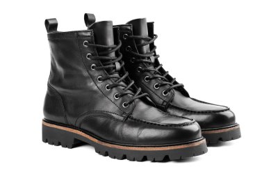 Pair of black leather boots, dress boots for men, men ankle high boots. Black brogue boots on a white background. Men fashion in leather boots. Man's legs in black jeans and brown leather boots.
