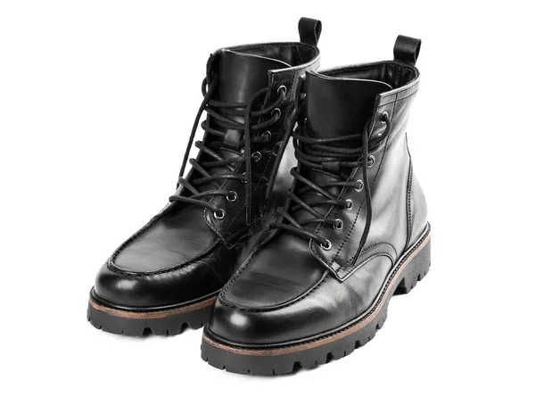 Pair of black leather boots, dress boots for men, men ankle high boots. Black brogue boots on a white background. Men fashion in leather boots. Man\'s legs in black jeans and brown leather boots.