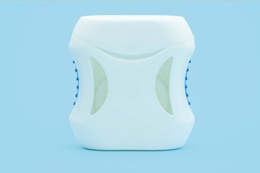 Diş ipli bir konteynır. Mavi arka planda diş ipi. Mavi arka planda diş ipi tutan genç kadın ellerini yakın çekim. Diş sağlığı ve ağız sağlığı konsepti.