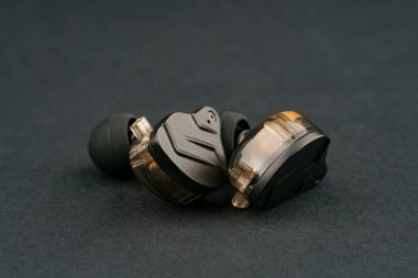 Tablo arka planındaki kulak monitöründe. Siyah plakalı özel kulak monitörleri. Bir müzisyenin konserde sahnede giymesi için özel kulaklık ya da el yapımı patlayıcılar..