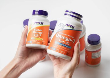 Dnipro, Ukrayna -09.09.2023: Bir şişe Omega 3-6-9 kadın elinde. Şimdi Gıda, Omega 3-6-9, balık yağı. Vejetaryen gıda takviyeleri.