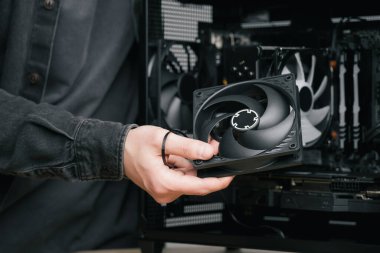 Bir bilgisayar teknisyeni bir bilgisayar güç kaynağı kuruyor. PC monte ediliyor
