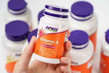 Dnipro, Ukrayna - 09.09.2023: Bir şişe A vitamini kadın elinde. Şimdi Yiyecekler, bir vitamin A 10,000 Vejetaryen gıda takviyesi.