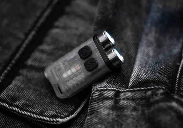 Pocket flashlight for Everyday Carry (EDC) on a dark background. Ray of light.
