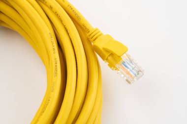 Sarı ağ kablosu, beyaz arka planda izole edilmiş. Bağlantı kablosu olan LAN kablolarını kapatın. İnternet ağı bağlantısı için Lan kablosu, beyaz arka planda gri Ian kablosu. Ethernet ağ kablo rulosu.