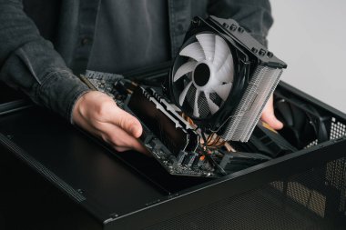 Bilgisayar teknisyeni bilgisayarın soğutma sistemi yükler. PC montaj