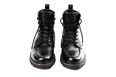 Pair of black leather boots, dress boots for men, men ankle high boots. Black brogue boots on a white background. Men fashion in leather boots. Man's legs in black jeans and brown leather boots.